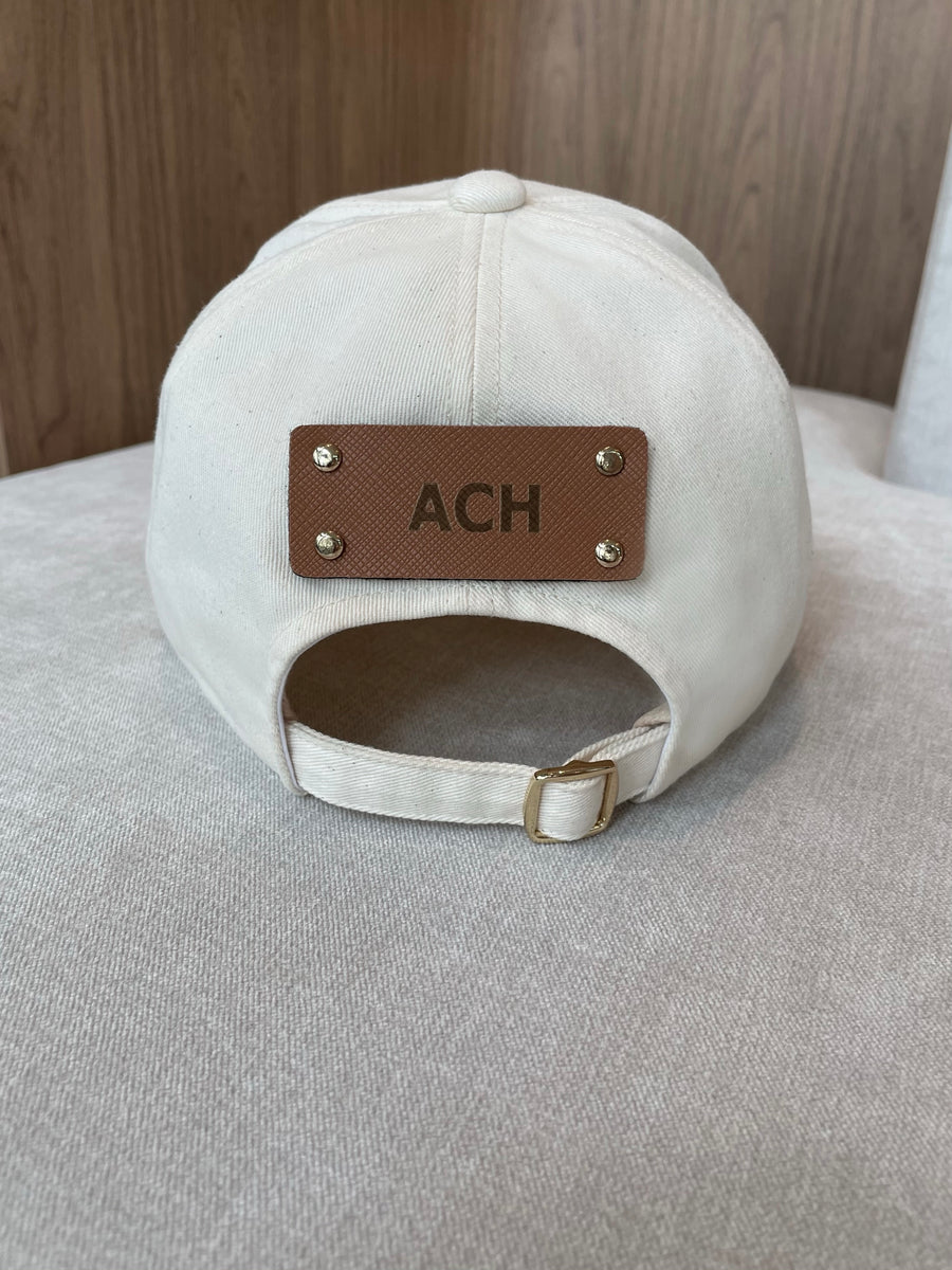 Luxury organic cream cotton cap with personalized vegan leather panel.